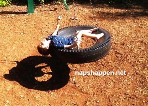 child asleep in tire swing