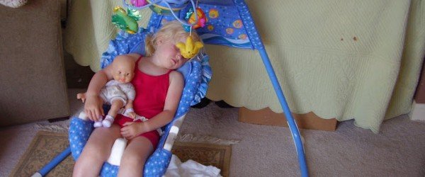 child asleep in baby swing